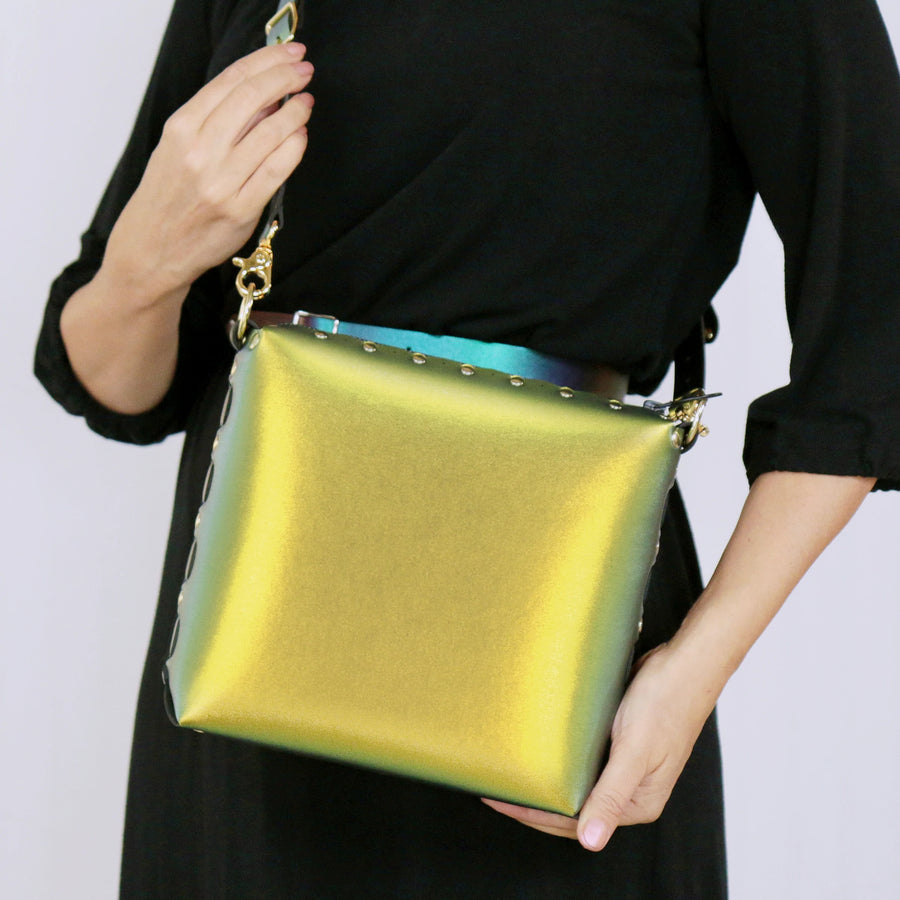 Model holding a scarab medium crossbody bag