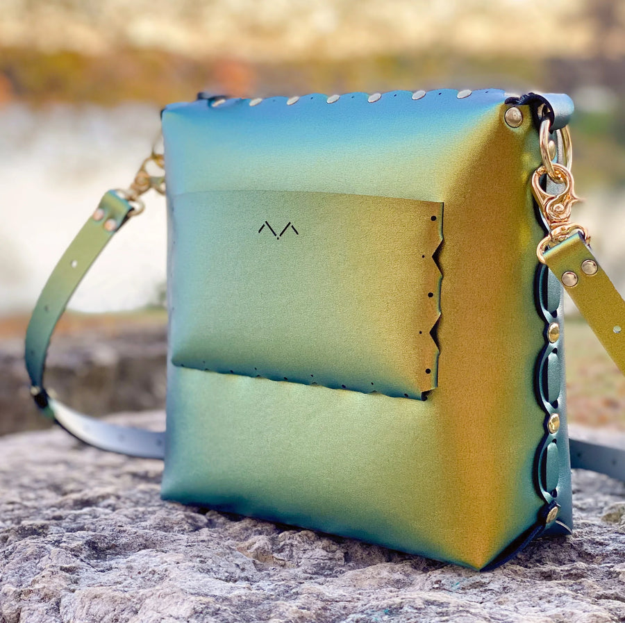 Scarab medium crossbody bag photographed under warm glow of autumn sunset